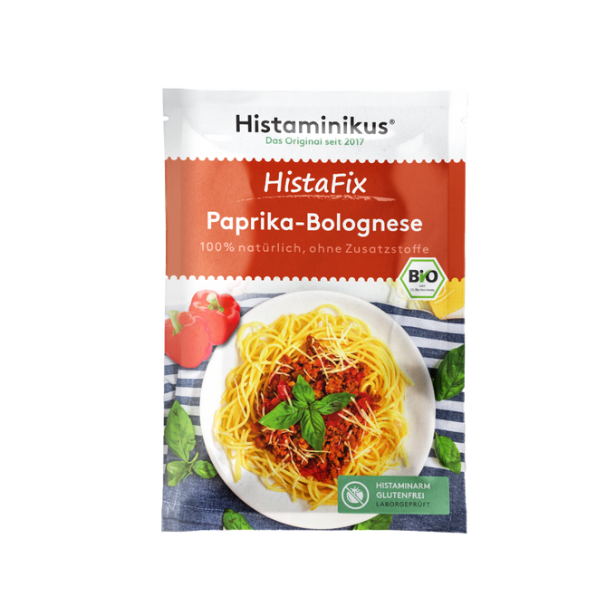 Ein einzelner HistaFix-Beutel „Paprika-Bolognese“ von Histaminikus mit rotem Verpackungsdesign, Teller Spaghetti mit Paprika-Hackfleischsoße, Basilikumblättern und Bio-Siegel, darunter grünes Label „histaminarm, glutenfrei, laborgeprüft“.