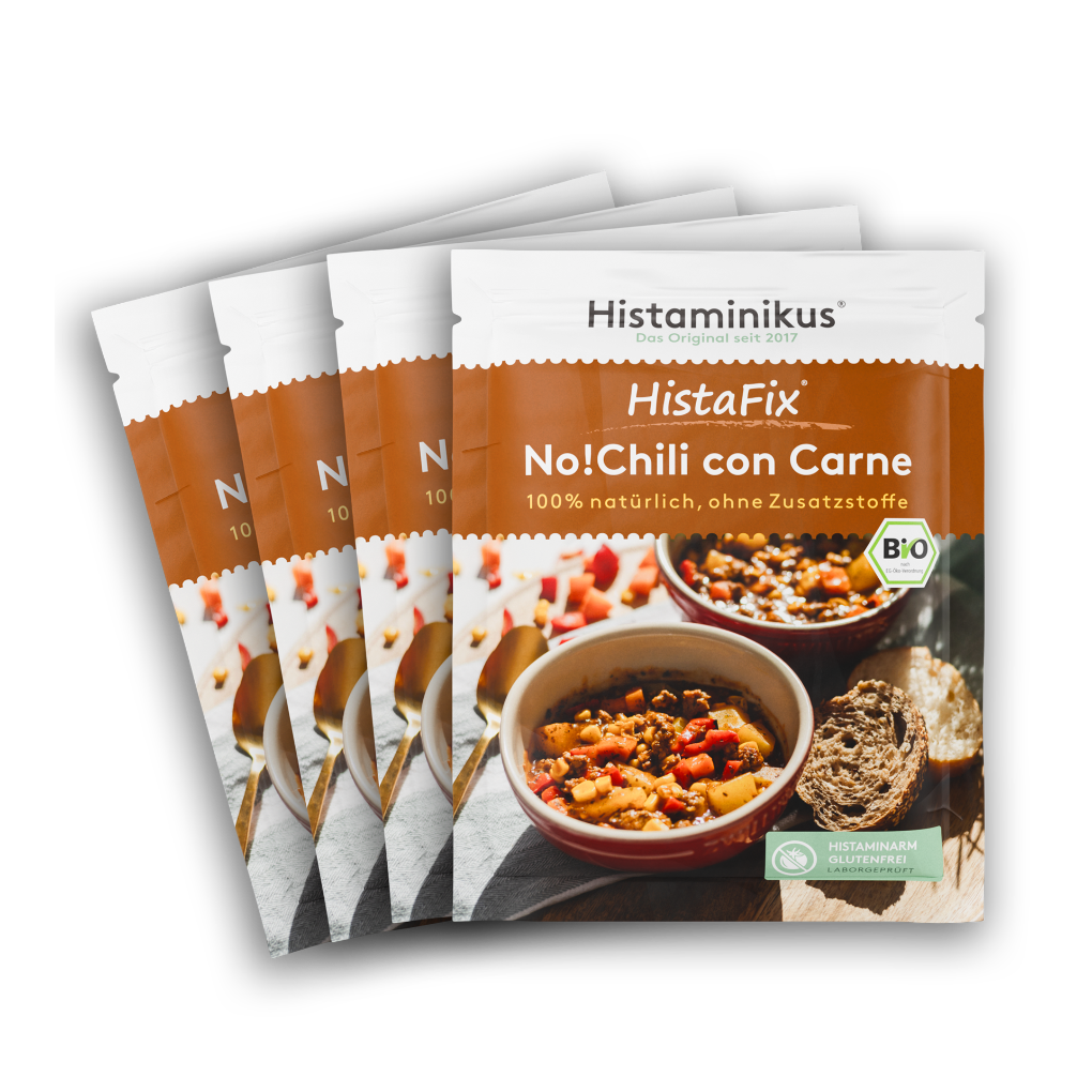 Vier nebeneinander gelegte HistaFix-Beutel „No!Chili con Carne“ von Histaminikus, mit einer Schale würzigem veganem Chili auf der Vorderseite, warm-braunes Verpackungsdesign mit Bio-Siegel und dem Hinweis „histaminarm, glutenfrei, laborgeprüft“.