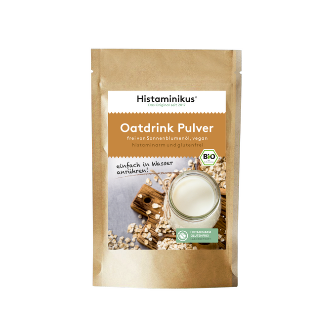Braune Standbeutelverpackung von Histaminikus Oatdrink Pulver mit Glas Hafermilch und Bio- sowie Histaminfrei-Siegel auf dem Etikett.