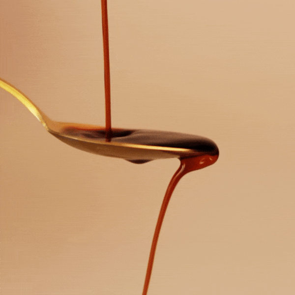 In einem kurzen Video sieht man den Balsamico auf einen goldenen Esslöffel fließen. Von dort fließt er weiter hinunter vom Löffel.