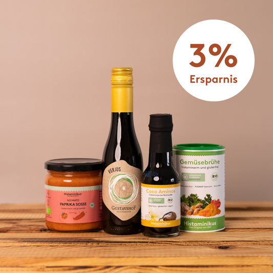 Vier histaminarme Produkte von Histaminikus – Paprikasoße, Verjus, Coco Aminos und Gemüsebrühe – auf einem Holztisch vor beigem Hintergrund, daneben ein Kreis mit dem Hinweis „3 % Ersparnis“.