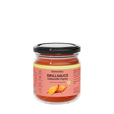 Glas mit Etikett "Grillsauce Süßkartoffel -Paprika" und schwarzem Deckel. Der Inhalt ist dunkelrot und wird als histaminam und glutenfrei bezeichnet. Auf dem Etikett sind zwei Süßkartoffeln zu sehen.