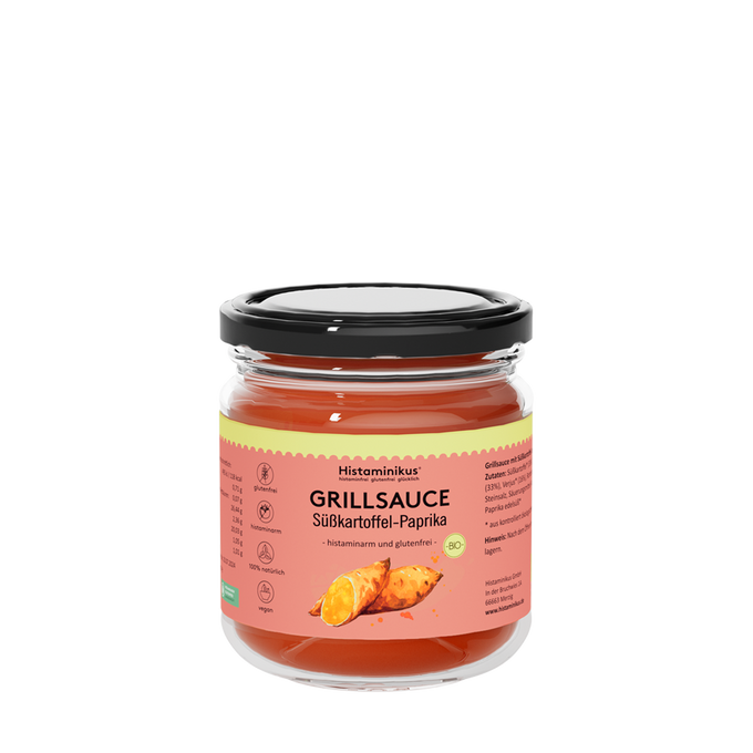 Glas mit Etikett "Grillsauce Süßkartoffel -Paprika" und schwarzem Deckel. Der Inhalt ist dunkelrot und wird als histaminam und glutenfrei bezeichnet. Auf dem Etikett sind zwei Süßkartoffeln zu sehen.