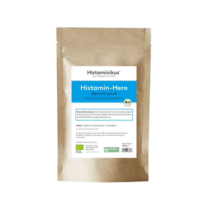 Beigefarbene Nachfüllverpackung mit blauem Etikett. Produktname „Histamin-Hero“, darunter die Angabe „histaminarm und glutenfrei“. Beschreibung: vollmundiger Kräutertee mit Nelken-Zitronennote zur Unterstützung bei Histaminintoleranz. BIO-Siegel vorhanden.