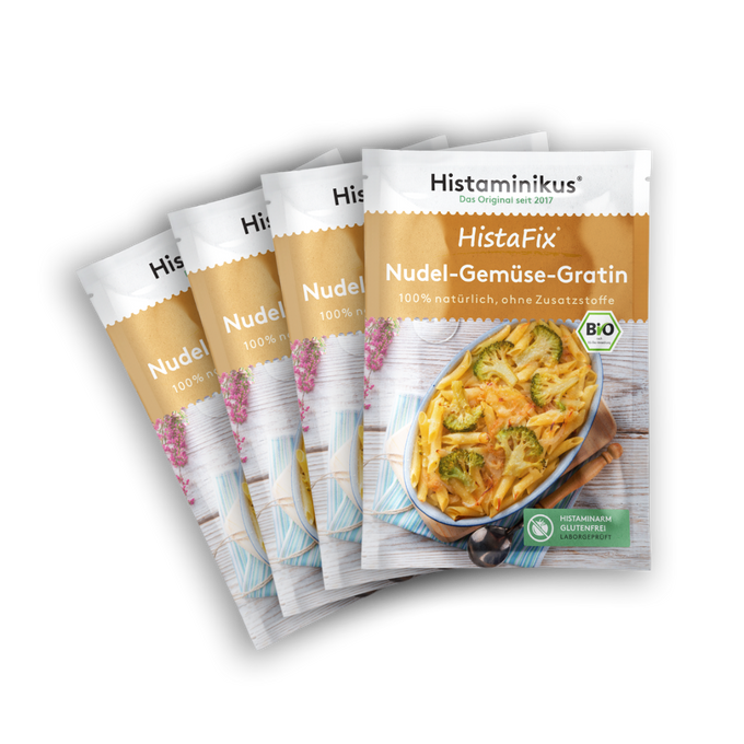 Vier nebeneinander gelegte HistaFix-Beutel „Nudel-Gemüse-Gratin“ von Histaminikus mit einem überbackenen Gratin aus Penne und Brokkoli auf der Vorderseite, braun-weißes Verpackungsdesign mit Bio-Siegel und Hinweis „histaminarm, glutenfrei, laborgeprüft“.