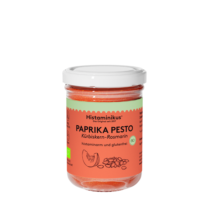 Glas mit dem Aufdruck Paprikapesto und weißem Deckel. Der Inhalt ist orange und wird als histaminarm und glutenfrei bezeichnet. Unter dem Paprikapesto steht "Kürbiskern-Rosmarin" und es ist eine kleine Zeichnung einer Scheibe Kürbis und Kürbiskernen zu sehen.
