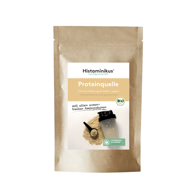 Produktfoto der „Proteinquelle“-Mischung von Histaminikus. Die Verpackung zeigt Pulver, Dosierlöffel und Shaker auf hellem Untergrund. Aufdruck mit Hinweisen wie „frei von Süßungsmitteln“, „vegan“, „histaminarm und glutenfrei“ sowie „mit allen essentiellen Aminosäuren“. Bio-Siegel und laborgeprüft-Icon ergänzen das Design.