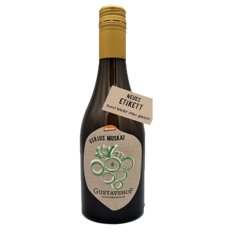 Braune Glasflasche mit goldfarbenem Schraubverschluss. Auf dem Etikett steht „VERJUS MUSKAT“ sowie „Gustavshof – Biodynamisch“ mit einer stilisierten grünen Traubengrafik. Ein zusätzlicher Anhänger am Flaschenhals trägt die Aufschrift „NEUES ETIKETT – Sonst bleibt alles gleich!“.