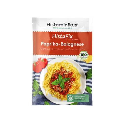 Ein einzelner HistaFix-Beutel „Paprika-Bolognese“ von Histaminikus mit rotem Verpackungsdesign, Teller Spaghetti mit Paprika-Hackfleischsoße, Basilikumblättern und Bio-Siegel, darunter grünes Label „histaminarm, glutenfrei, laborgeprüft“.