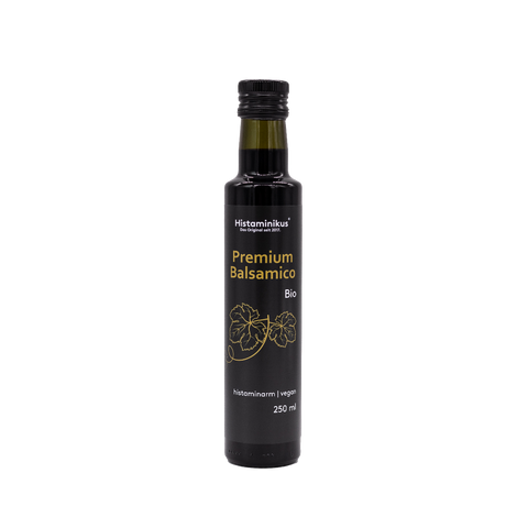Eine schwarze, schmale Flasche mit schwarzem Deckel und der Aufschrift "Premium Balsamico Bio". Die Flasche wird als histaminarm und vegan bezeichnet. Unter der Aufschrift sind zwei Weinblätter abgebildet.