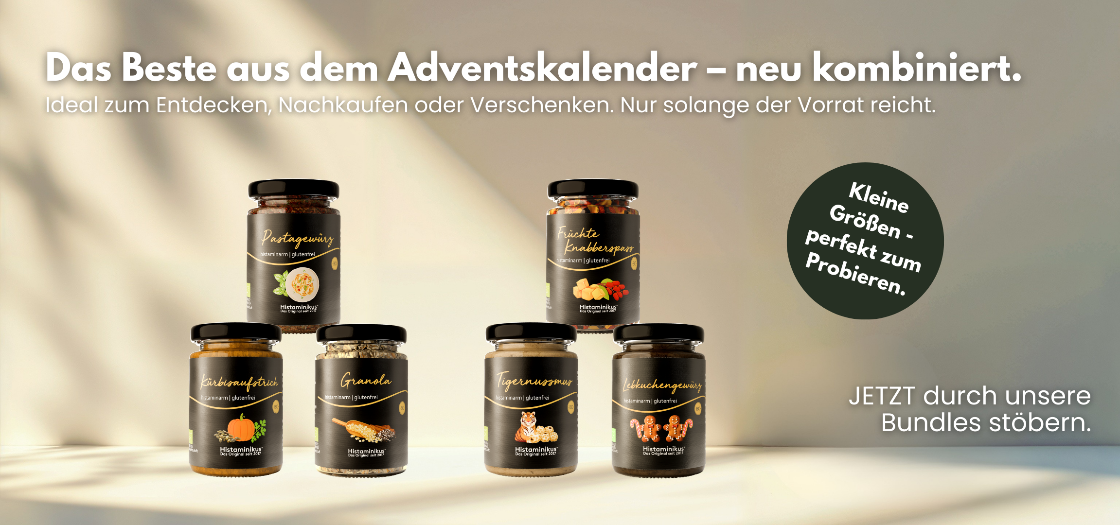 Translation missing: de.Banner mit der Überschrift „Das Beste aus dem Adventskalender – neu kombiniert.“ Mehrere Histaminikus-Produkte in kleinen Gläsern sind auf einer hellen Fläche arrangiert, darunter Pastagewürz, Kürbisaufstrich, Granola, Tigernussmus, Lebkuchengewürz und Früchte Knabberspaß. Rechts ein grüner Kreis mit dem Text „Kleine Größen – perfekt zum Probieren.“ Darunter der Hinweis „Jetzt durch unsere Bundles stöbern."