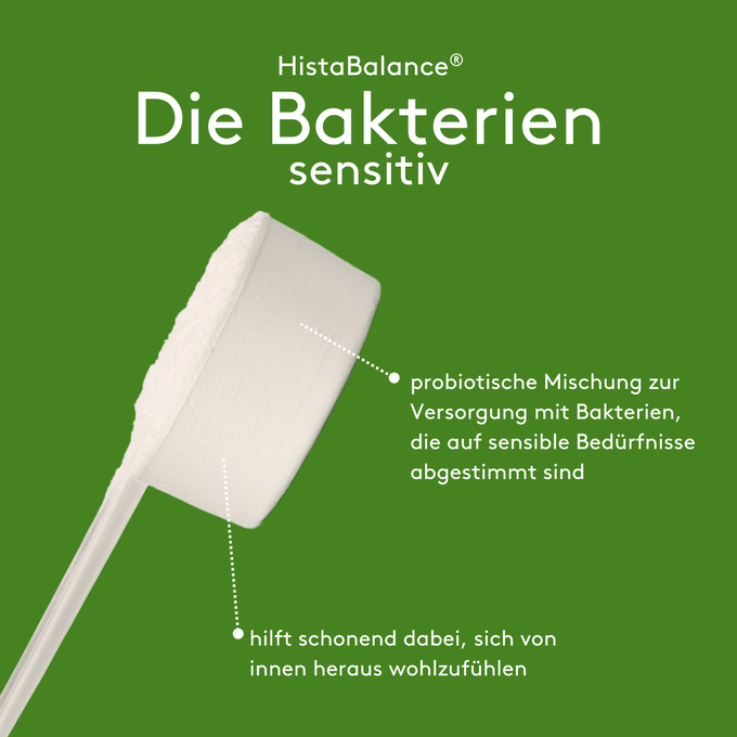 Grafisches Produktmotiv „HistaBalance® Die Bakterien sensitiv“ auf grünem Hintergrund. Abgebildet ist ein weißer Messlöffel mit Pulver. Pfeilmarkierungen erklären die probiotische Mischung für sensible Bedürfnisse sowie den Hinweis auf ein schonendes Wohlgefühl von innen heraus.