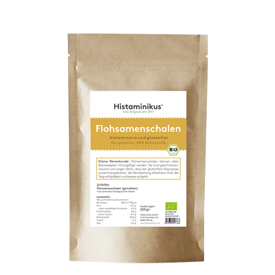Braune Papierverpackung mit weißem Etikett. Produktname „Flohsamenschalen“ in großer gelber Schrift, darunter Beschreibung „histaminarm und glutenfrei, fein gemahlen, 80 % Ballaststoffe“. Mit Bio-Siegel und Infotext zur Verwendung.
