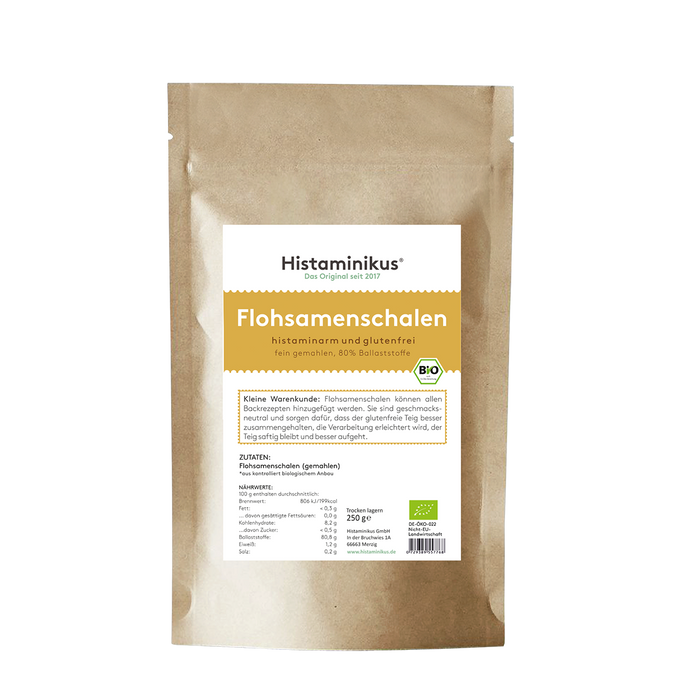 Braune Papierverpackung mit weißem Etikett. Produktname „Flohsamenschalen“ in großer gelber Schrift, darunter Beschreibung „histaminarm und glutenfrei, fein gemahlen, 80 % Ballaststoffe“. Mit Bio-Siegel und Infotext zur Verwendung.