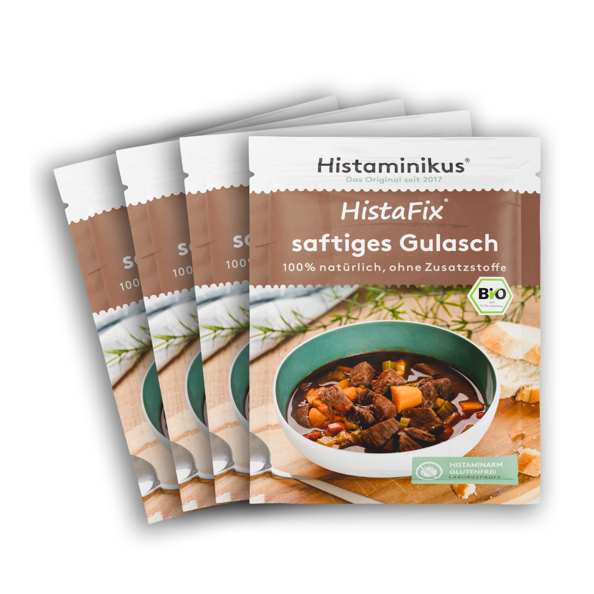 Vier Tütchen „HistaFix saftiges Gulasch“ nebeneinander. Vorderseite in Braun-Weiß mit Abbildung eines deftigen Gulaschs in einer Schale. Beschriftung: „100 % natürlich, ohne Zusatzstoffe“. Mit Bio-Siegel und Kennzeichnung „histaminarm, glutenfrei, laborgeprüft“.