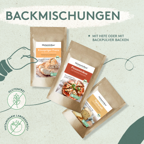 Grafik mit drei braunen Standbodenbeuteln für Backmischungen: „Knuspriger Franz“, „Pizzaminikus“ und „Tipharah“. Beschriftet mit „Backmischungen – mit Hefe oder mit Backpulver backen“. Unten links Icons für „glutenfrei“ und „histaminarm laborgeprüft“. Hintergrund in sanftem Grün mit gezeichnetem Pfeil.