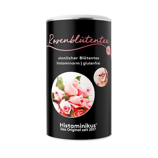Schwarze Dose Rosenblütentee mit rosa Schriftzug, Rosenmotiv und Text „sinnlicher Blütentee, histaminarm, glutenfrei“ auf weißem Hintergrund.