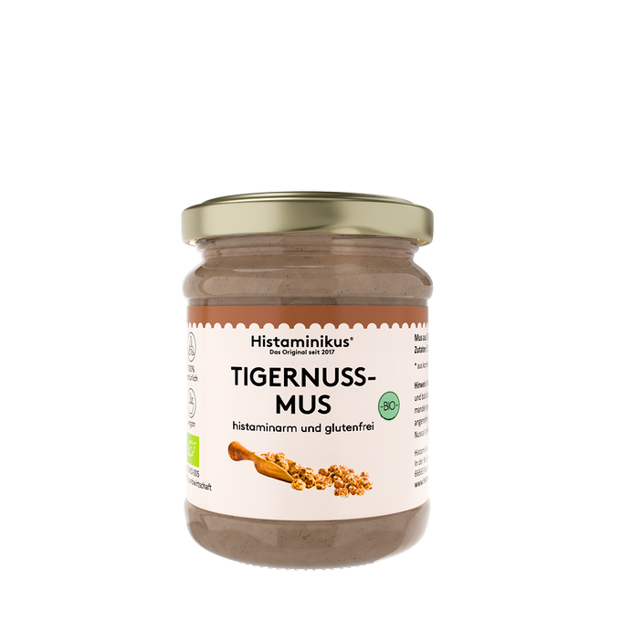 Glas Histaminikus Tigernussmus mit goldenem Schraubdeckel. Das Etikett ist in Weiß und Beige gestaltet und zeigt die Aufschrift „TIGERNUSS-MUS“, „histaminarm und glutenfrei“ sowie ein grünes Bio-Siegel. Unten auf dem Etikett ist eine kleine Holzschaufel mit Tigernussstückchen abgebildet.