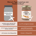 Vergleichsgrafik in zwei Spalten mit der Überschrift „Warum Tigernussmus von Histaminikus?“. Links ist ein graues Glas mit der Aufschrift „Herkömmlicher Aufstrich“ und einem weißen X dargestellt, rechts ein Glas Histaminikus Tigernussmus mit weißem Haken. Darunter werden die Unterschiede hervorgehoben: links „enthält meist viele bei HIT unverträgliche Zutaten“, rechts „nur HIT verträgliche Zutaten“; links „oft mit Zucker, Zusatzstoffen und Aromen versehen“, rechts „ganz OHNE Zusatzstoffe und Geschmacksverst