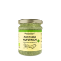 Glas mit goldfarbenem Deckel, gefüllt mit grünem Zucchini-Aufstrich. Auf dem cremefarbenen Etikett stehen Marke, Produktname und Hinweise wie „histaminarm und glutenfrei“, ergänzt durch ein kleines Bio-Siegel und eine gezeichnete Zucchini und Basilikum. Rechts und links sind weitere Produktinformationen angedeutet. 