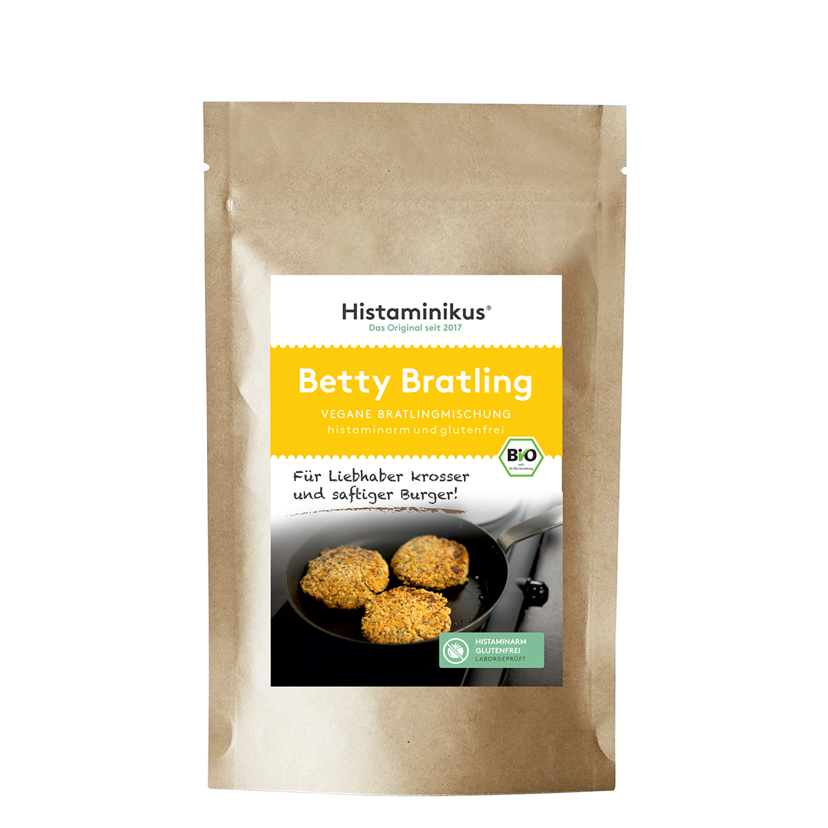 Braune Standbodenverpackung mit Etikett des Produkts „Betty Bratling“. Oben auf dem Etikett der Schriftzug „Histaminikus, Das Original seit 2017“. Darunter gelbes Feld mit Produktname „Betty Bratling“ und Hinweis „vegane Bratlingmischung, histaminarm und glutenfrei“. Im unteren Bereich des Etiketts ein Foto von drei goldbraunen Bratlingen in einer schwarzen Pfanne. BIO-Siegel und Symbol für histaminarm und glutenfrei sichtbar.
