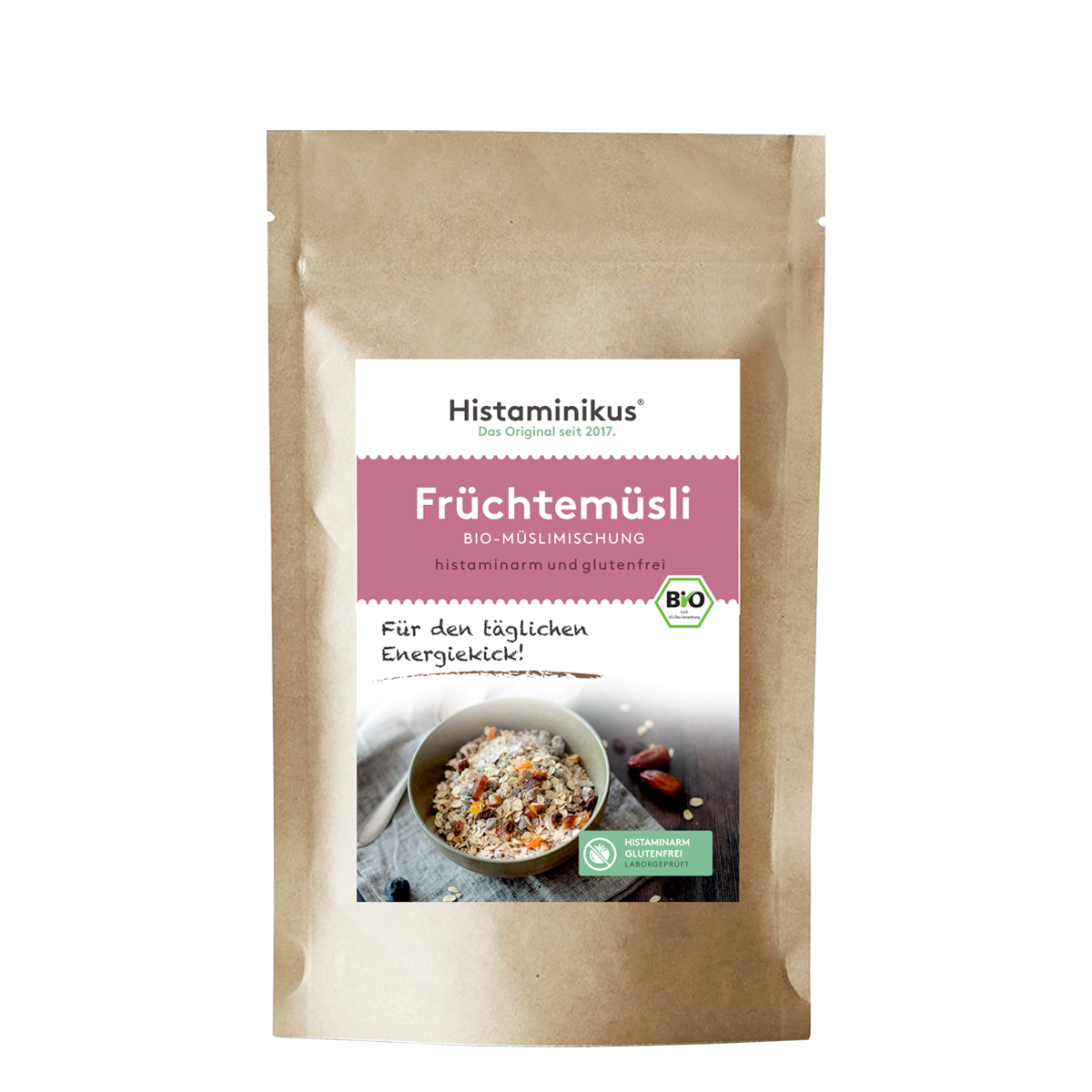 Braune Papierverpackung mit weißem Etikett. Produktname „Früchtemüsli“ in rosa Schrift, darunter „Bio-Müslimischung, histaminarm und glutenfrei“. Foto einer Müslischale mit Löffel und Trockenfrüchten.