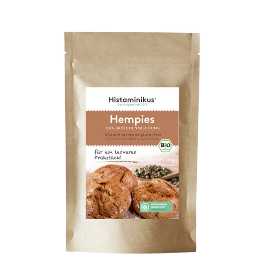 Standbodenverpackung aus braunem Papier mit weißem Etikett. Beschriftet mit „Hempies – Bio-Brötchenmischung“. Darunter Foto von drei Brötchen.
Mit dem Text: „für ein leckeres Frühstück!“ und Bio-Siegel.