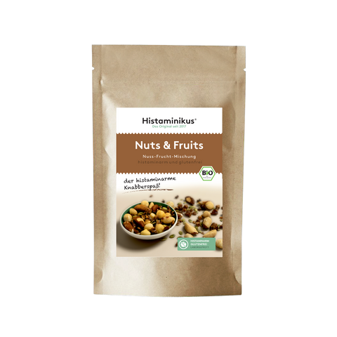 Braune Verpackung mit Etikett „Nuts & Fruits – Nuss-Frucht-Mischung“.
Darunter: „histaminarm und glutenfrei“ sowie „der histaminarme Knabberspaß!“
Abgebildet ist eine Schale mit Nüssen und Trockenfrüchten.
Grünes Siegel: „Histaminarm, glutenfrei, laborgeprüft“.
BIO-Logo oben rechts.