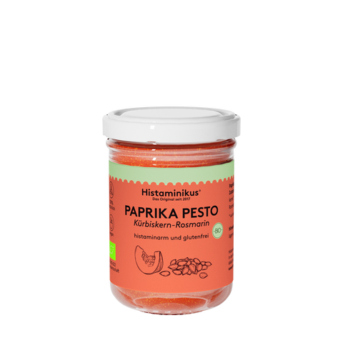 Glas mit dem Aufdruck Paprikapesto und weißem Deckel. Der Inhalt ist orange und wird als histaminarm und glutenfrei bezeichnet. Unter dem Paprikapesto steht "Kürbiskern-Rosmarin" und es ist eine kleine Zeichnung einer Scheibe Kürbis und Kürbiskernen zu sehen.