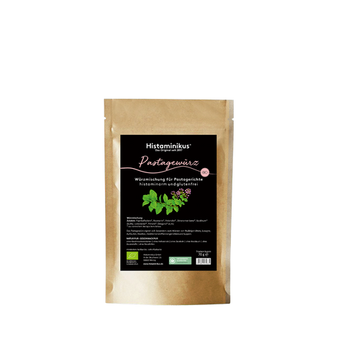Standbeutel mit brauner Papieroptik und schwarzem Etikett von Histaminikus. Auf der Vorderseite steht „Pastagewürz“ in rosa Schreibschrift sowie „Würzmischung für Pastagerichte, histaminarm und glutenfrei“. Darunter ist eine Illustration grüner Kräuter mit kleinen violetten Blüten zu sehen. Unten auf dem Etikett stehen Zutatenangaben, Bio-Hinweis, Prüfhinweis, Herstellerangaben und das Gewicht von 70 g.