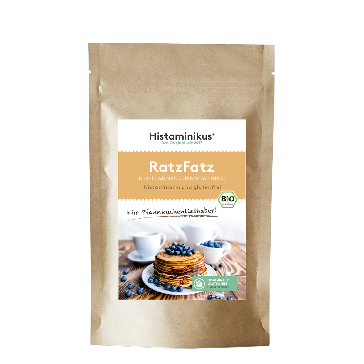 Produktfoto der „RatzFatz“ Bio-Pfannkuchenmischung von Histaminikus. Auf der braunen Standbodenverpackung befindet sich ein Etikett mit Produktnamen, Beschreibung („histaminarm und glutenfrei“) sowie einem Bild von gestapelten Pfannkuchen mit Heidelbeeren. Unten das grüne Siegel „histaminarm – glutenfrei – laborgeprüft“ und das EU-Bio-Logo.